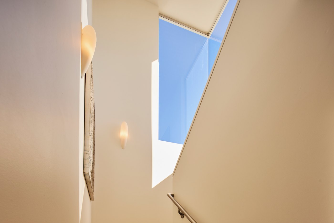Sculptural white wall and a sliver of blue sky